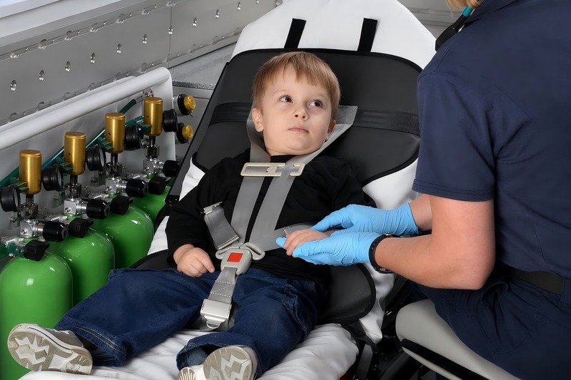 child secured on stretcher