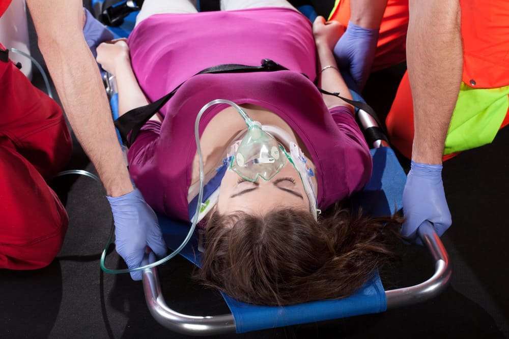 First responders carrying a patient on a folding stretcher