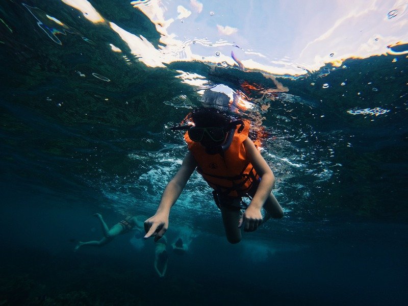 A worker in full gear with tools, highlighting the extra weight a life jacket must support.
