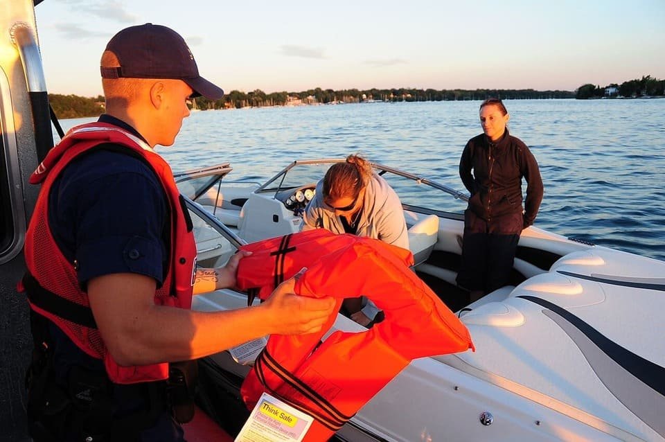 A Coast Guard officer inspecting life jackets during a boating safety check