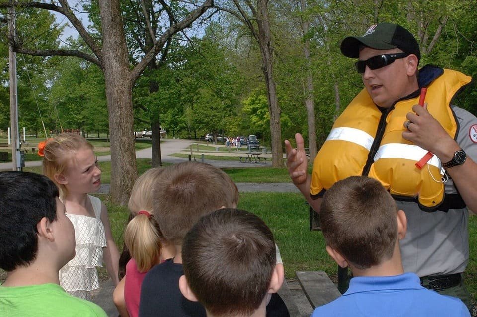 A safety educator demonstrating an inflatable personal flotation device