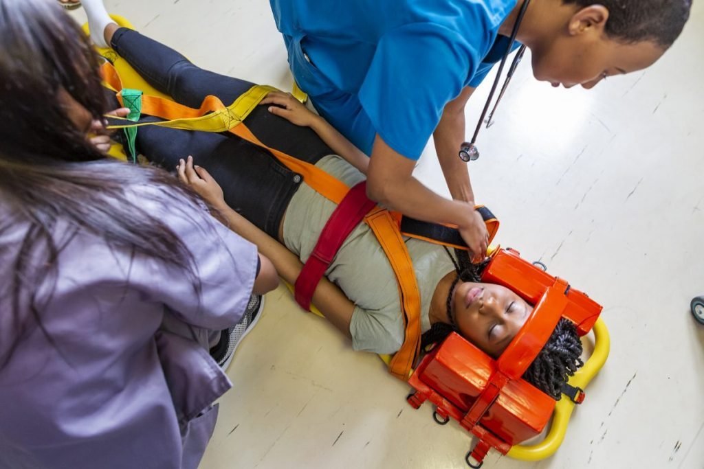 Emergency responders securing a patient with a head immobilizer on a spine board