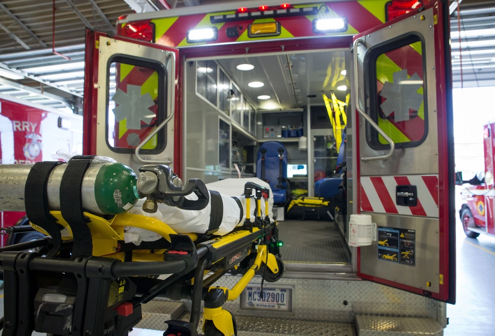 Wheeled stretcher positioned at the rear of an ambulance
