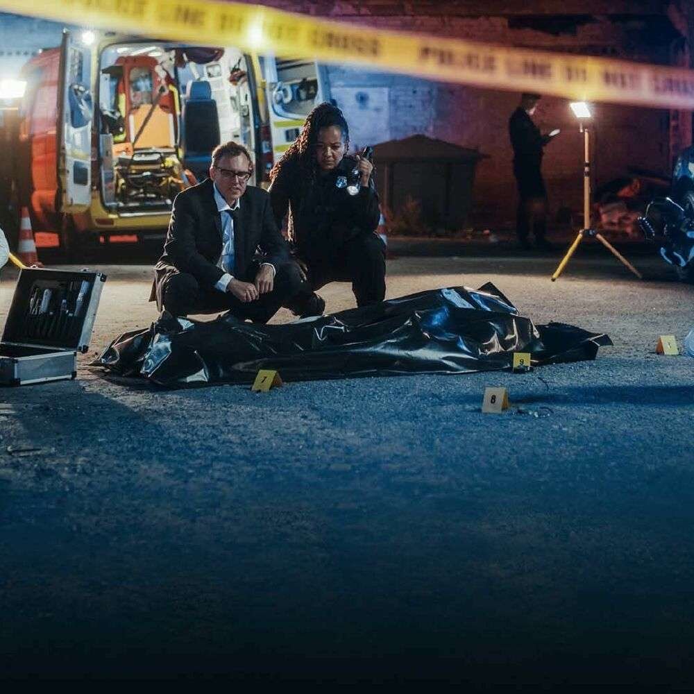Body Bag at a Forensic Investigation Scene Forensic investigators beside a body bag at a nighttime scene